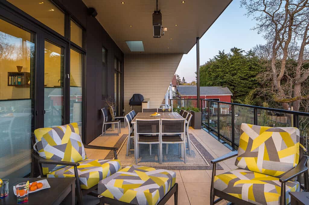 Modern outdoor patio space featuring stylish seating and a dining table, ideal for entertaining in a Custom Home setting.