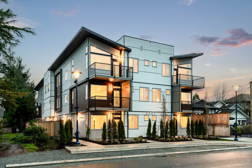 Modern Custom Home featuring a sleek exterior design with multiple balconies, large windows, and landscaped surroundings, showcasing contemporary architecture and urban living.