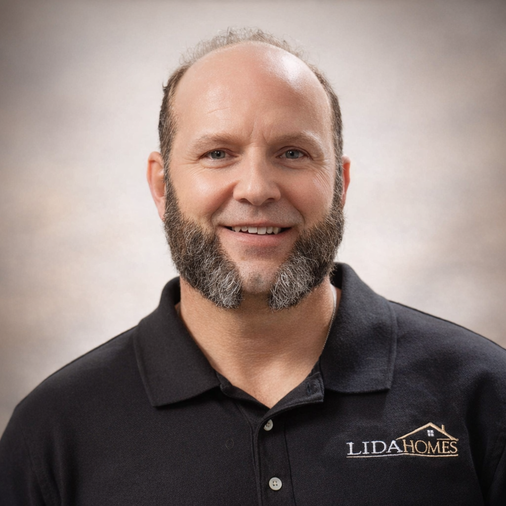 Professional portrait of a man in a black polo shirt with the logo of a Custom Home builder, showcasing expertise in home construction and design.